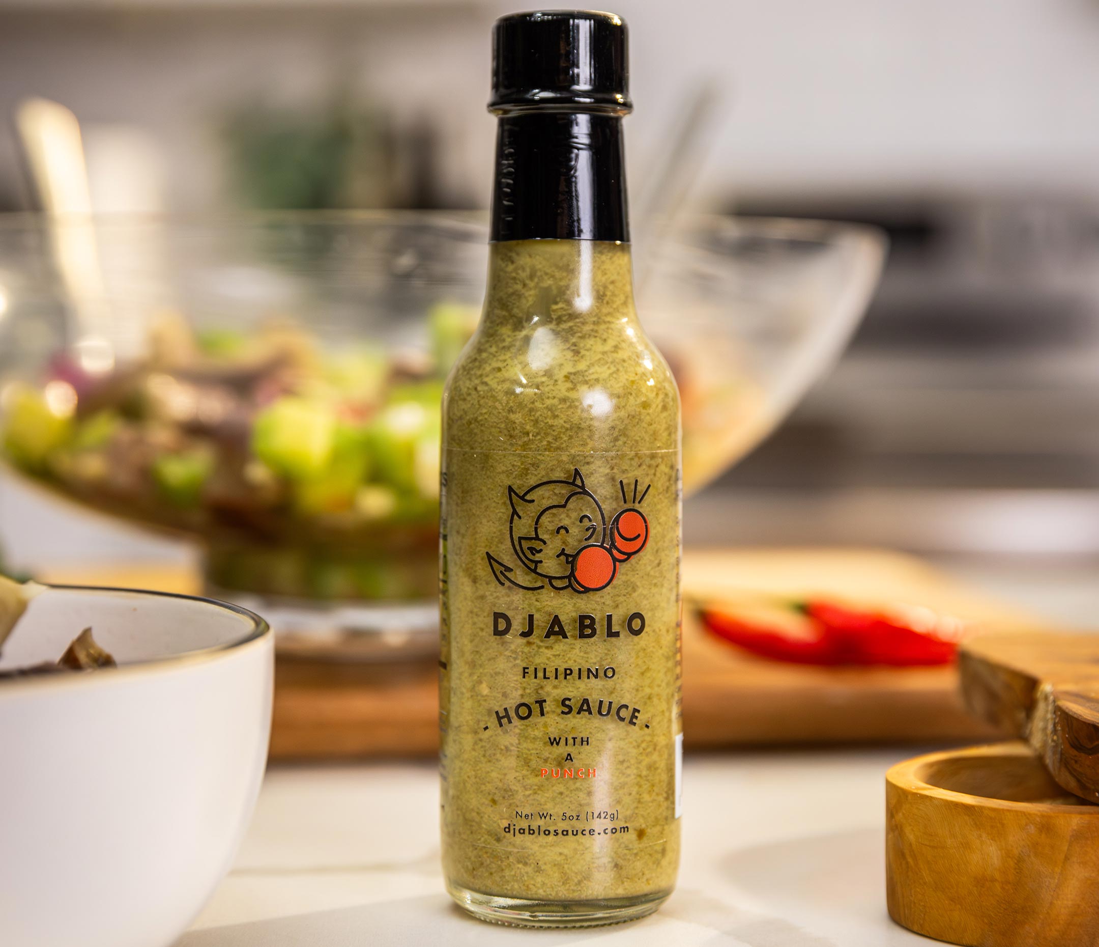 Bottle of Djablo Filipino hot sauce on a kitchen counter.