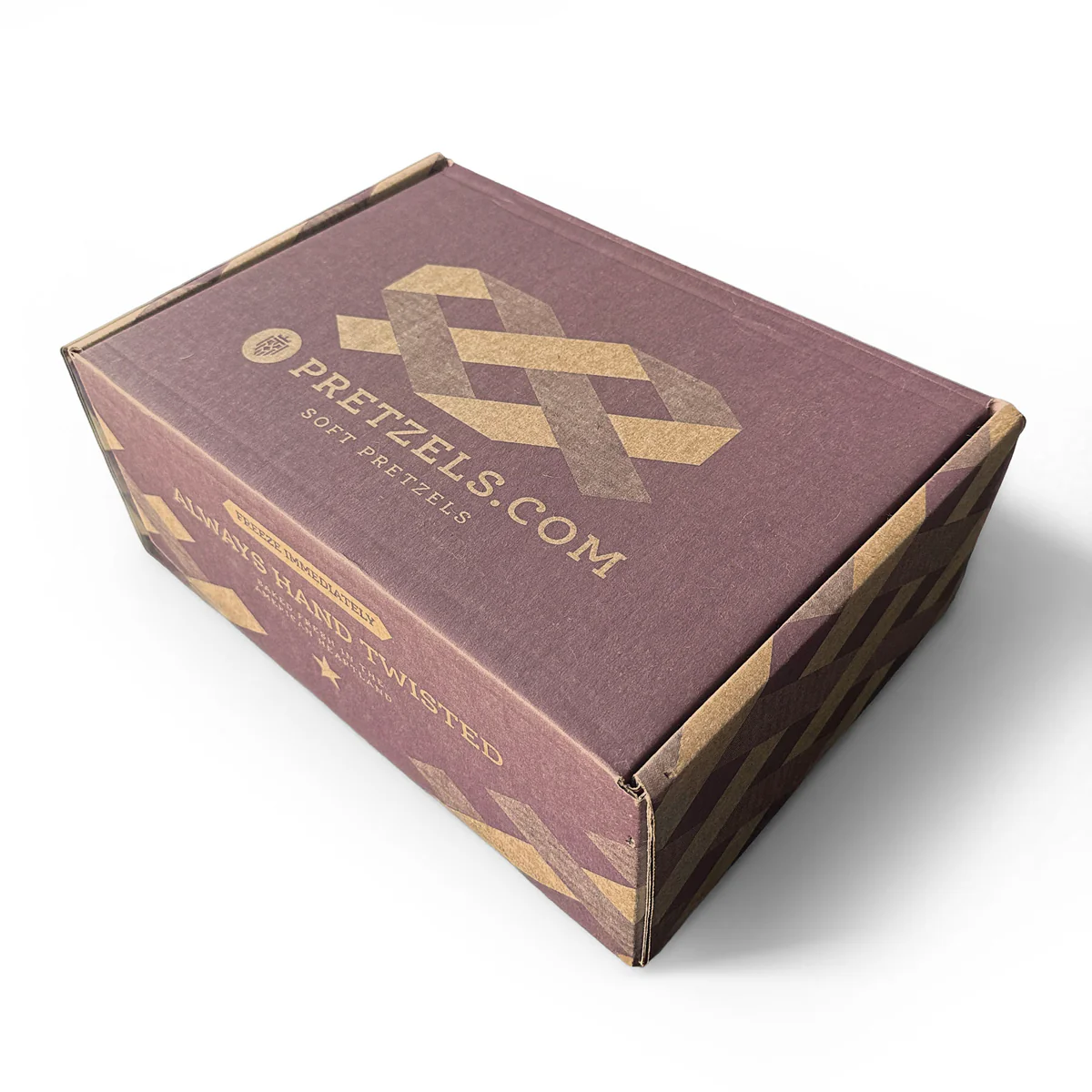 A closed cardboard shipping box for Pretzels.com soft pretzels, on a white background.
