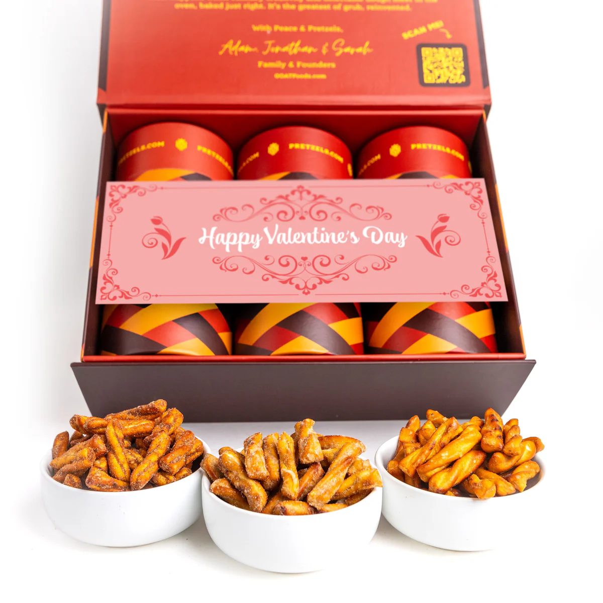 A Valentine's Day gift box with canisters and three bowls of seasoned pretzels on a white background.