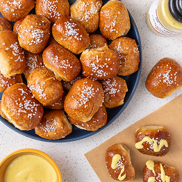 Plate of pretzel bites with mustard sauce and a jar of mustard.