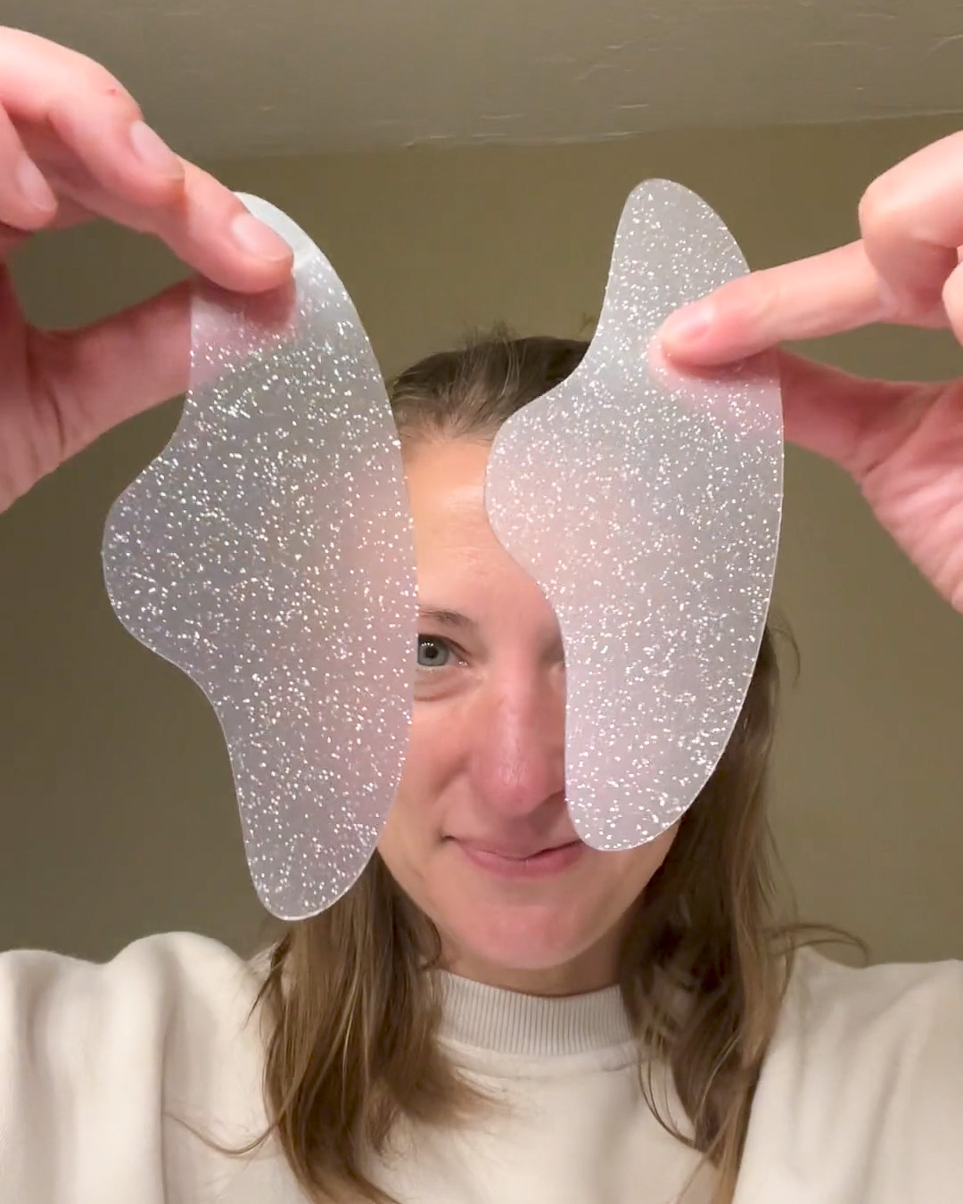 A woman holding up two Busy Signal Forehead patches