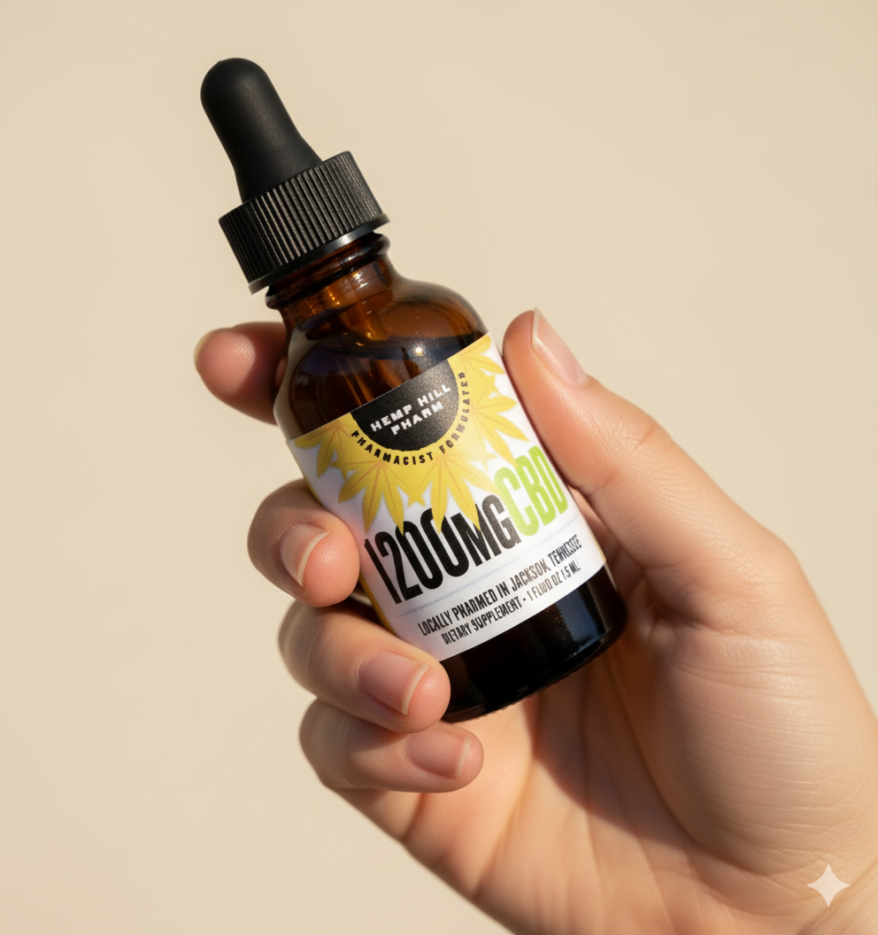 Hand holding a brown bottle with a dropper labeled '1200mg CBD.'