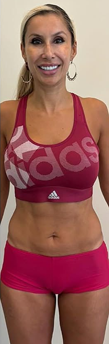 Person in pink Adidas athletic wear standing and smiling.