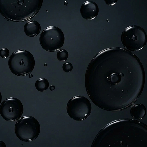 A close-up, abstract image of dark, glossy bubbles of various sizes against a dark grey background.