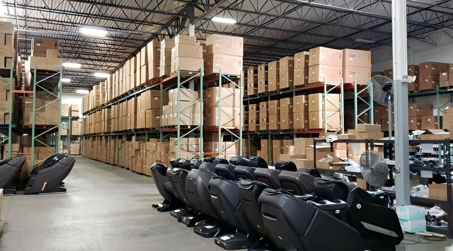 Warehouse with stacked boxes and rows of black car seats.