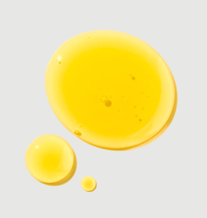 Three yellow liquid droplets on a light gray background.
