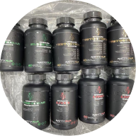An overhead shot of nine black supplement bottles with various labels, arranged in two rows.