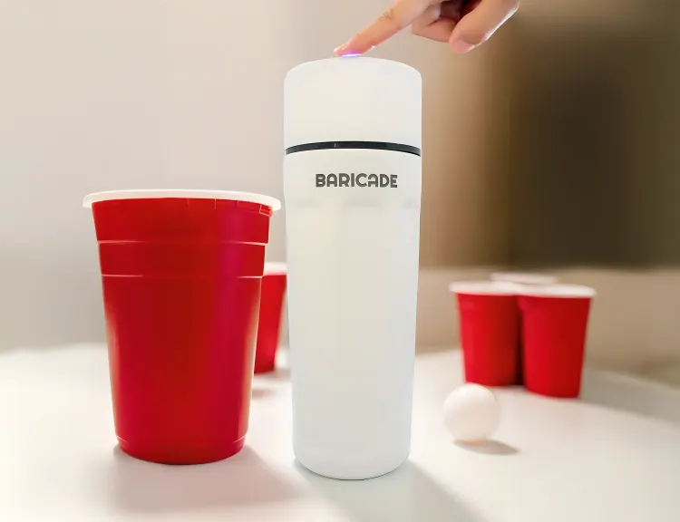 Red cups and a white container labeled 'BARICADE' on a table.