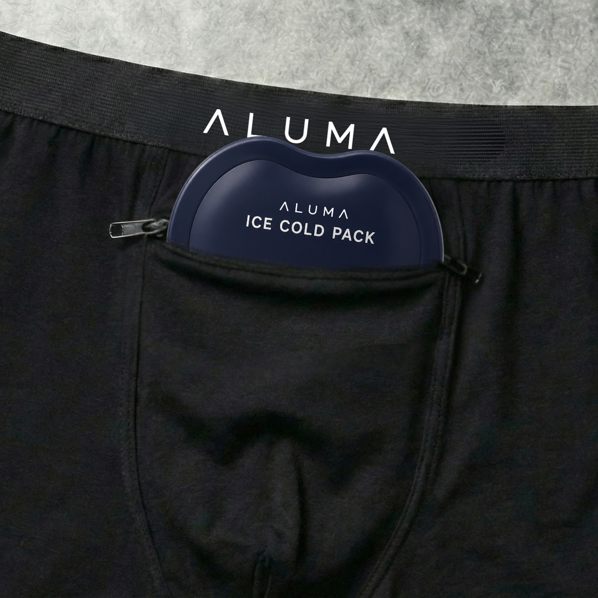 Close-up of black boxer briefs with a blue Aluma ice cold pack in the front zippered pocket.