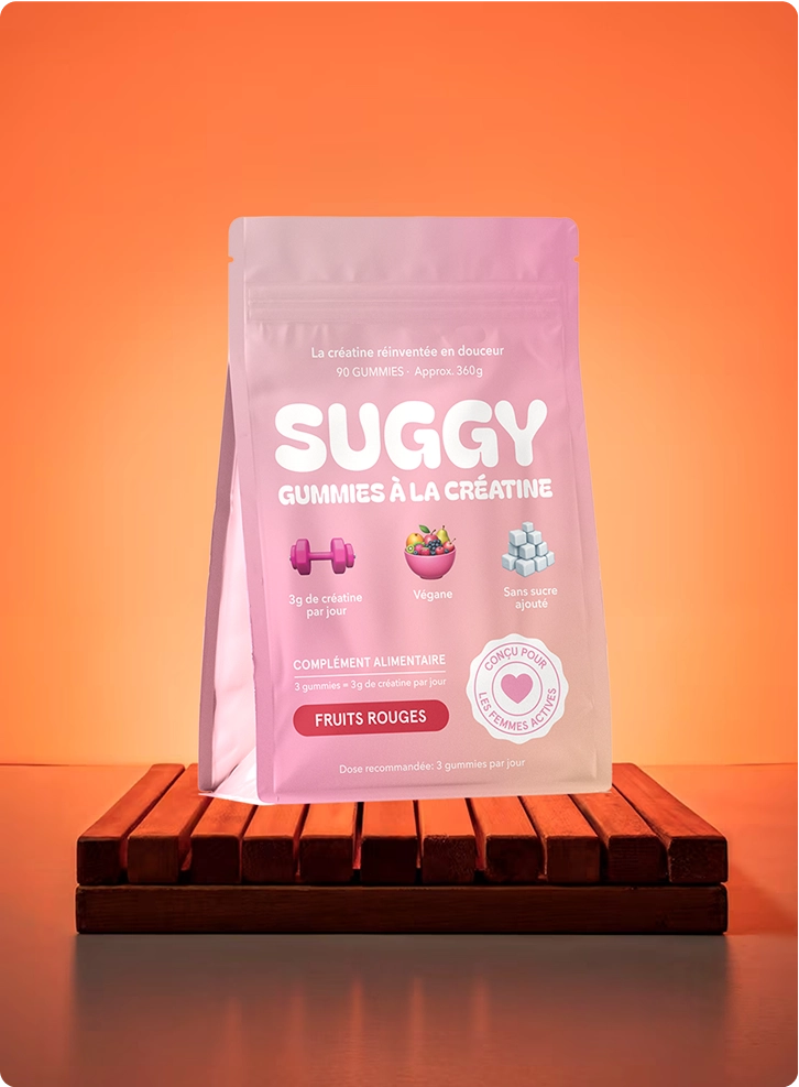 Pink bag of creatine gummies on a wooden platform, orange background.