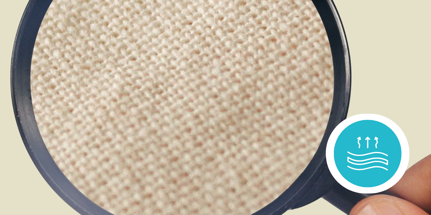 Magnifying glass showing a close-up of beige woven fabric.