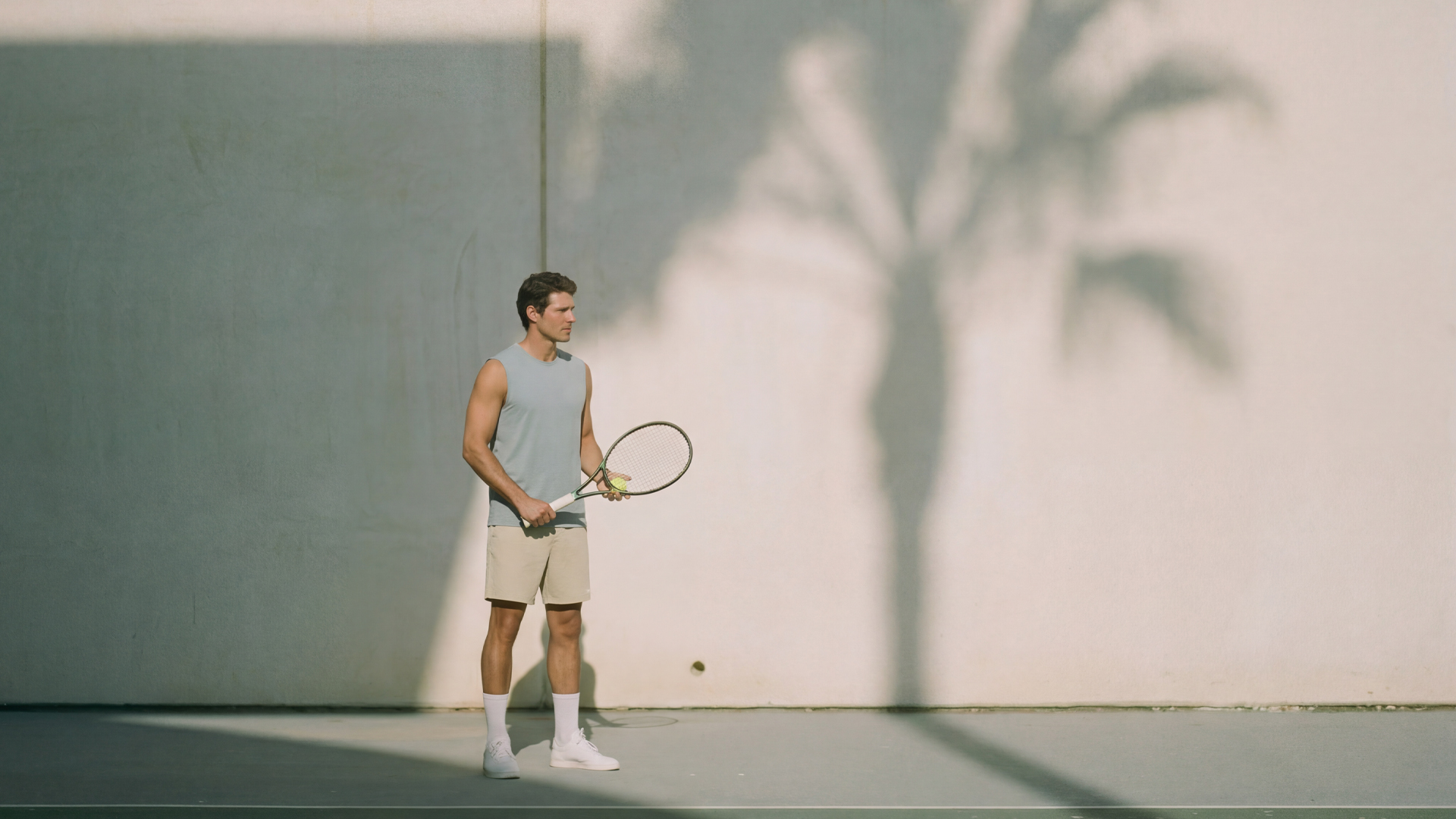 Three individuals in dark blue outfits standing in a dimly lit room.