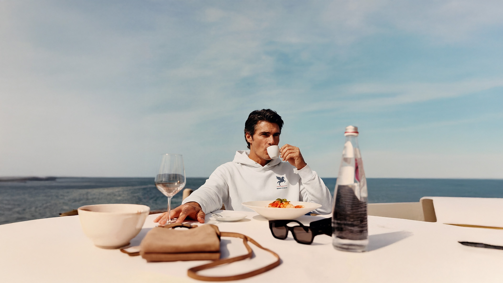 Three individuals in dark blue outfits standing in a dimly lit room.