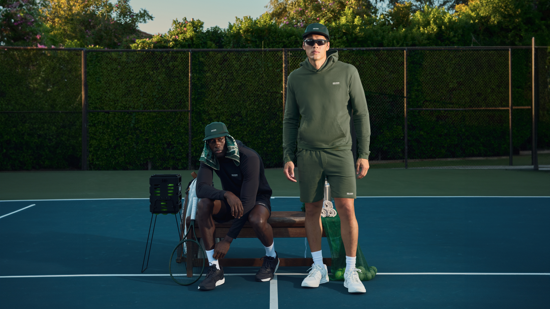 Two people in sportswear on a tennis court, one seated, one standing.
