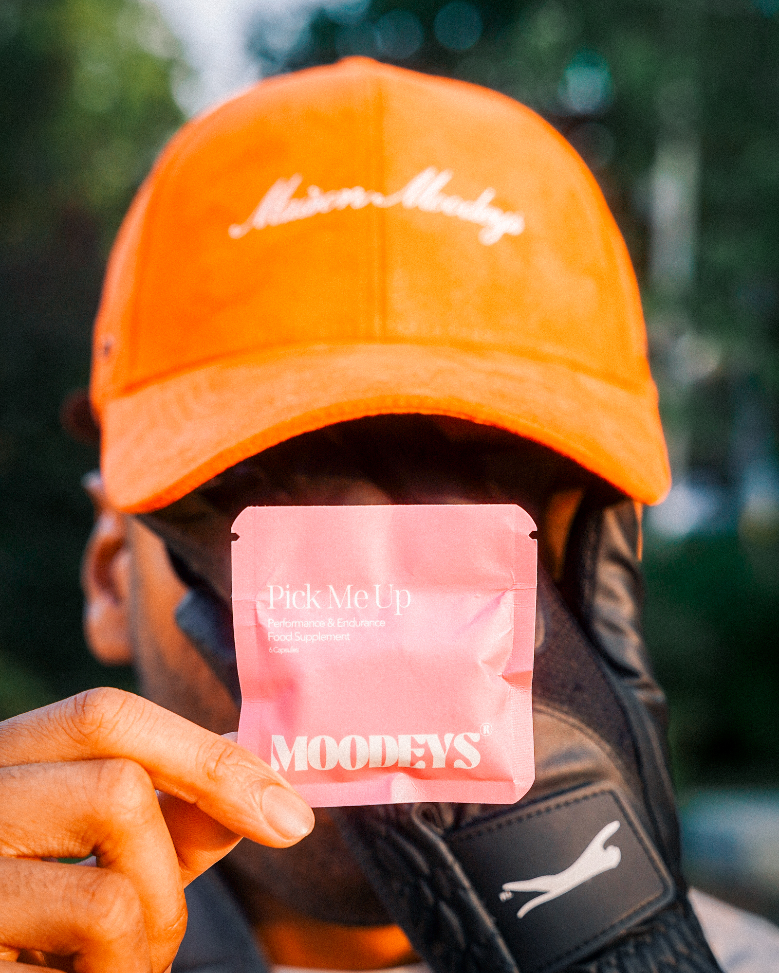 Person holding a pink packet labeled 'Pick Me Up' with an orange cap.