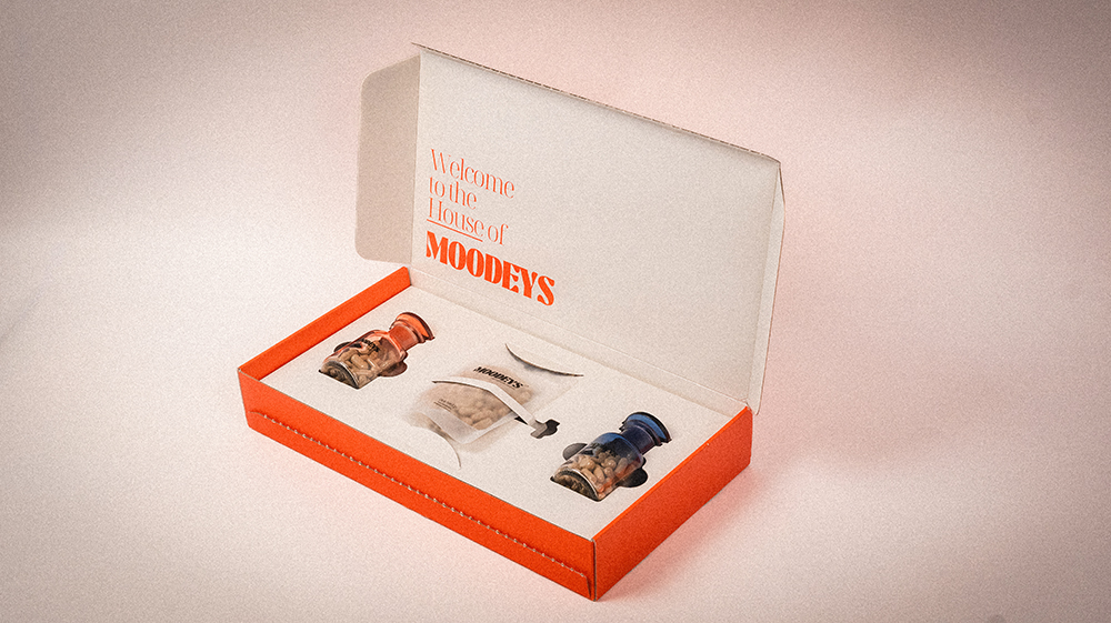 Open box with jars and a pouch, labeled 'Welcome to the House of MOODEYS.'