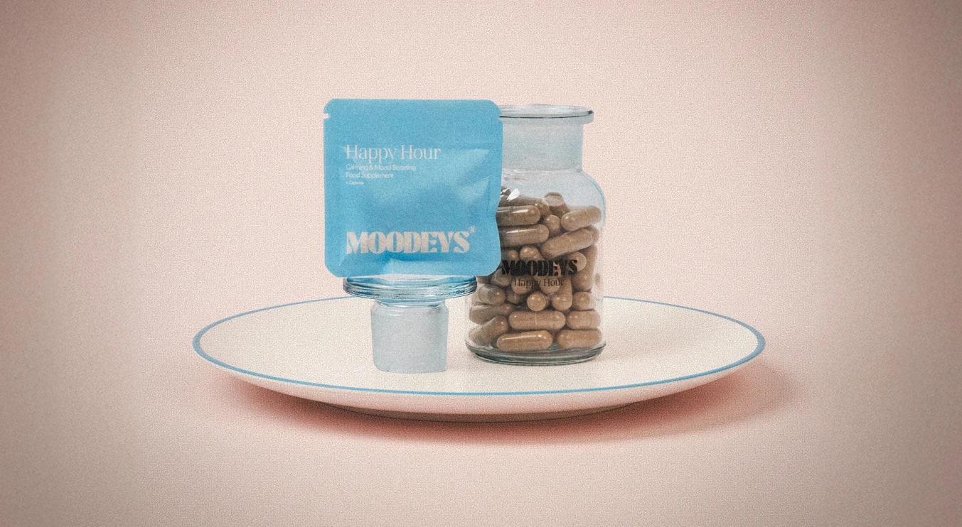A jar of capsules and a blue packet labeled 'Happy Hour' on a plate.