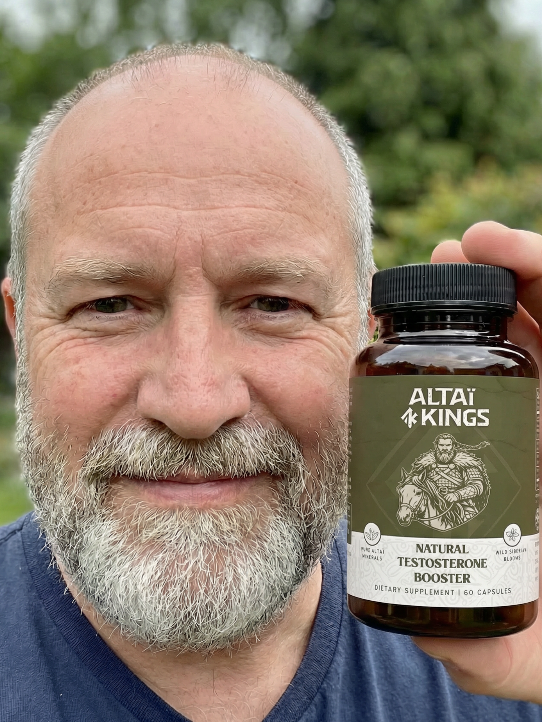 A smiling man with a gray beard holds up a bottle of Altai Kings Natural Testosterone Booster.