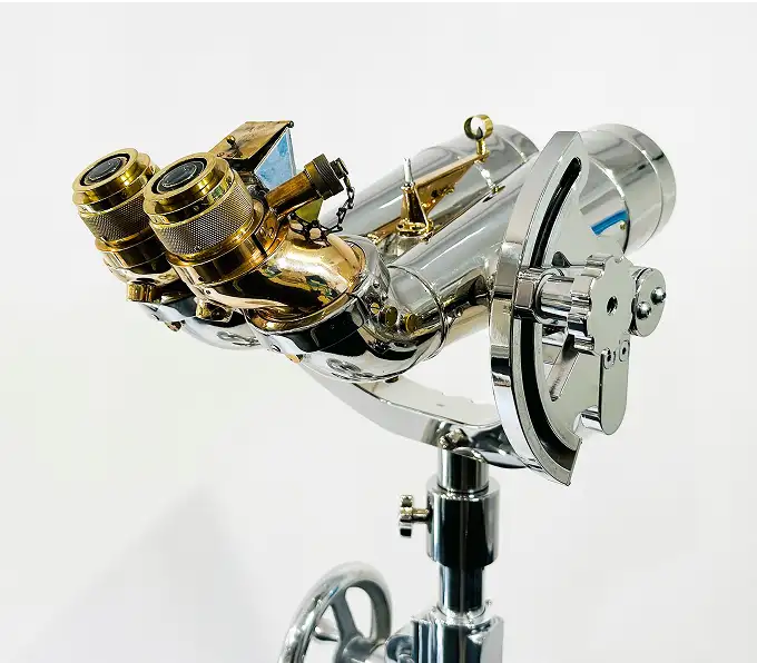 A pair of large, powerful binoculars made of chrome and brass, mounted on a stand against a white background.