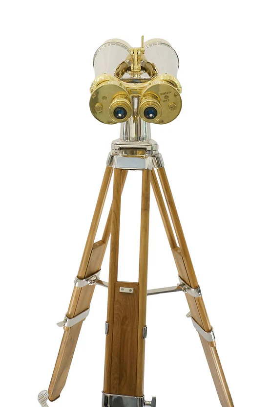 Gold and silver binoculars on a wooden tripod stand.