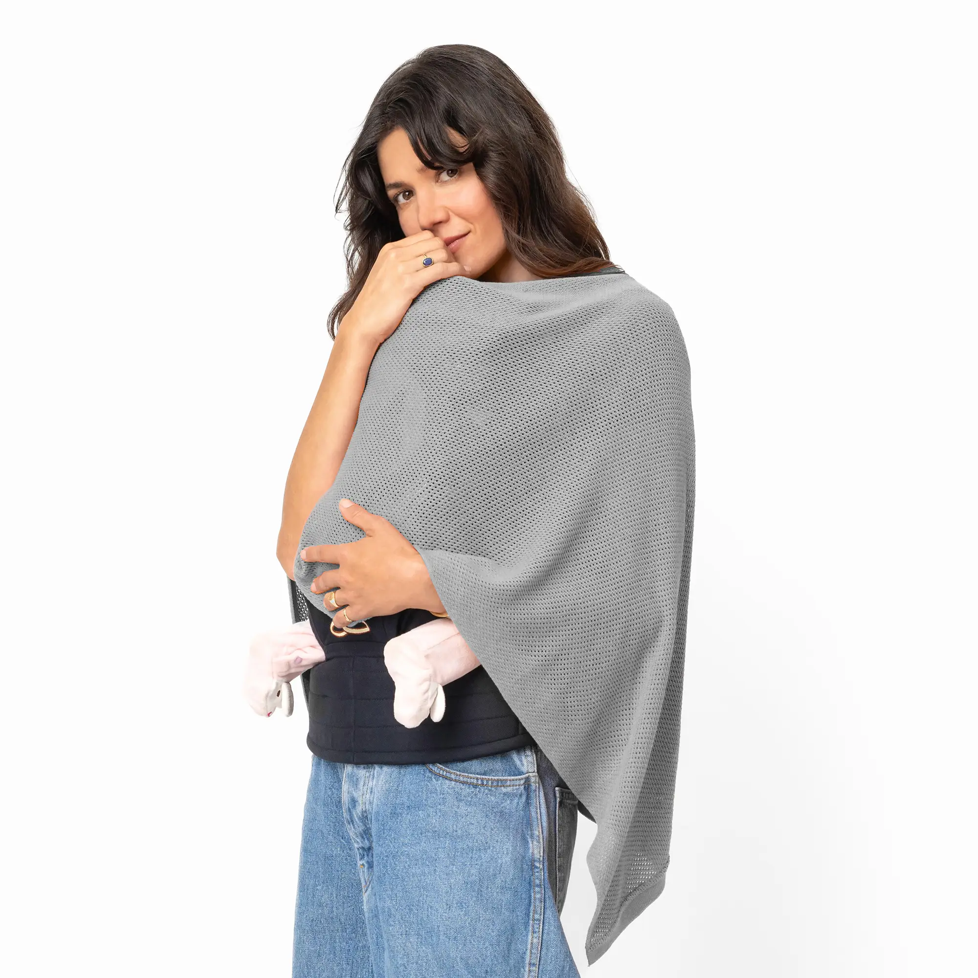 Woman holding a baby wrapped in a gray blanket.
