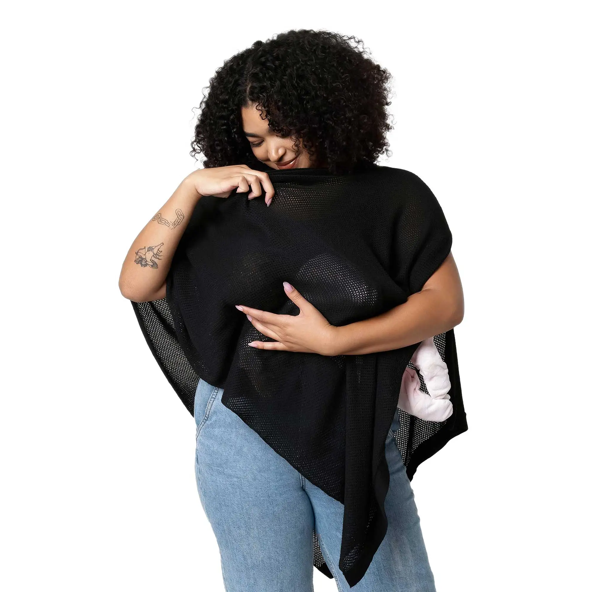 Person wearing a black mesh poncho over a white shirt, holding the fabric.