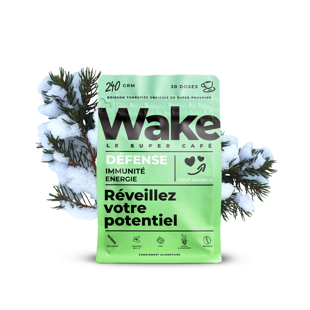 A green pouch of Wake Le Super Café Défense set against snowy pine branches on a white background.