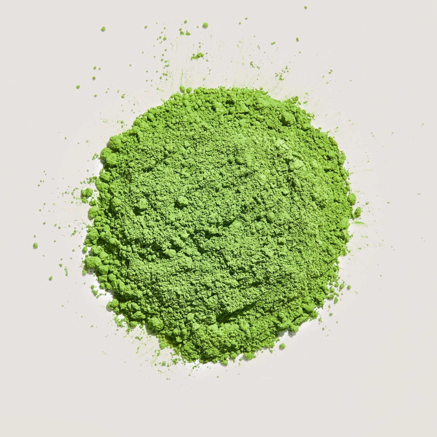A pile of bright green powder on a white background.