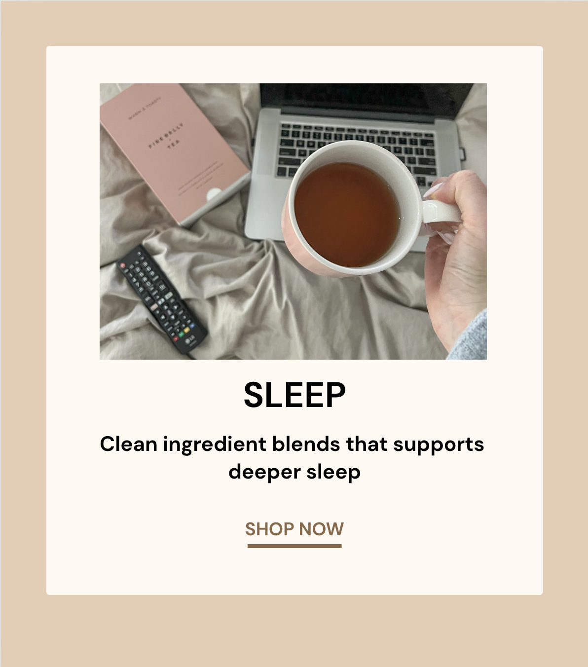 Person holding a mug of tea over a laptop, book, and remote on a bed.