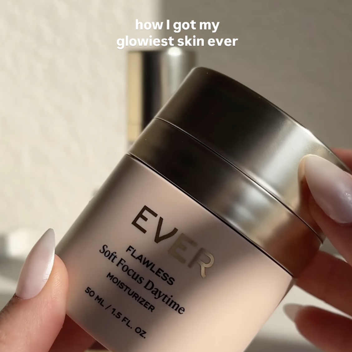 A person holding a jar of Ever Flawless Soft Focus Daytime Moisturizer.