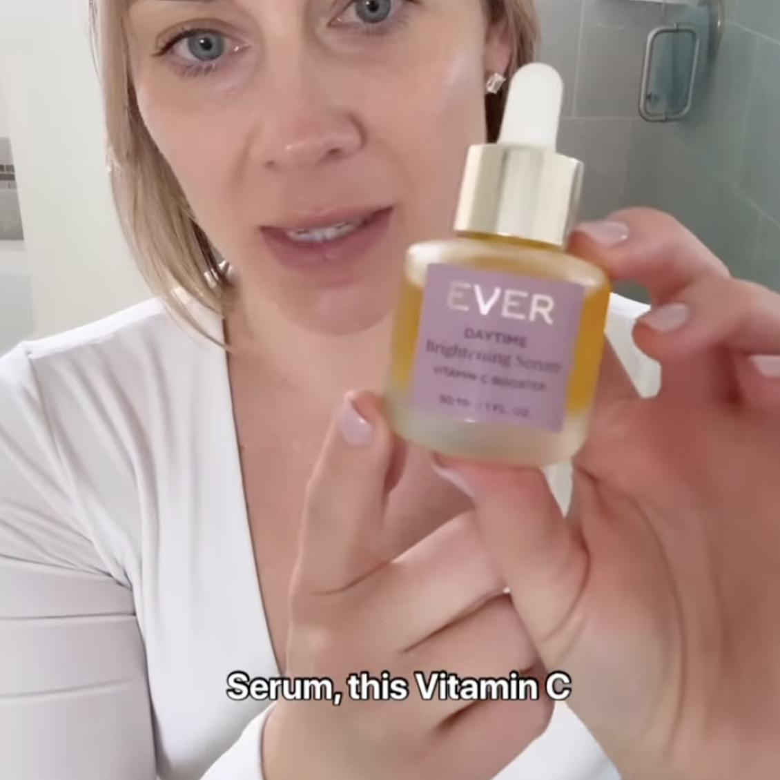 Person holding a bottle of Ever Daytime Brightening Serum.