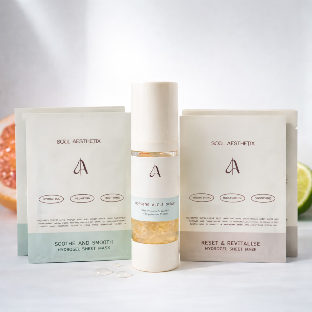 Soul Aesthetix serum and hydrogel sheet masks displayed with slices of citrus fruit on a white background.