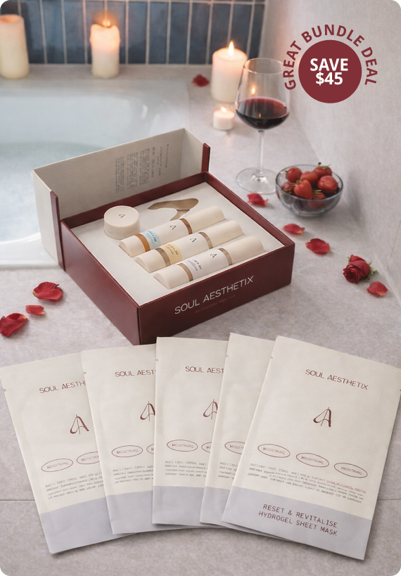 A skincare product set and sheet masks arranged by a candlelit bathtub with wine and strawberries.