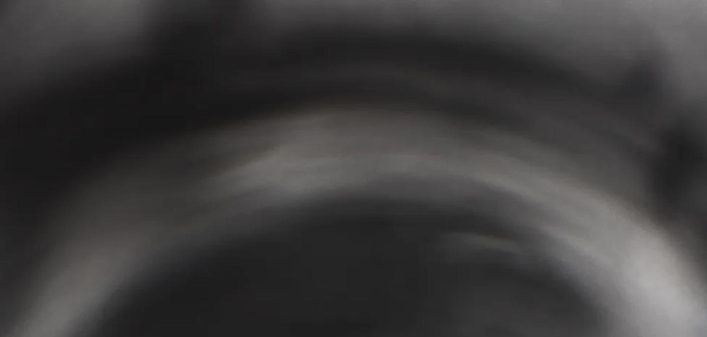 Blurry, abstract image with dark and light gray tones.