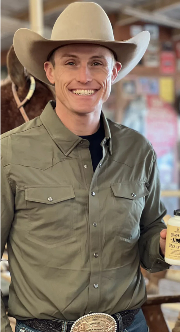 Person in a cowboy hat holding a jar, smiling indoors.