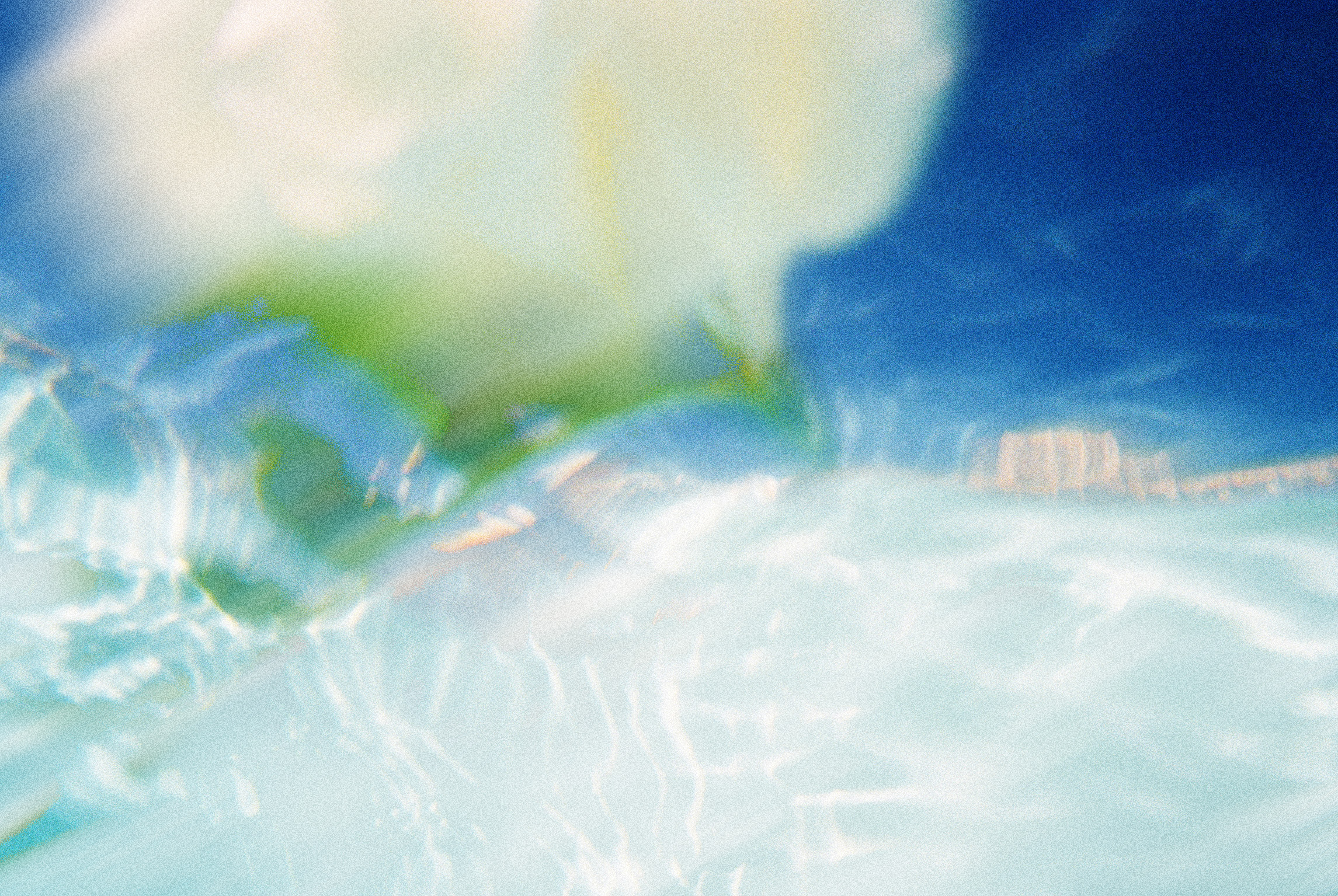 Abstract blur of blue, white, and green colors with rippling effect.