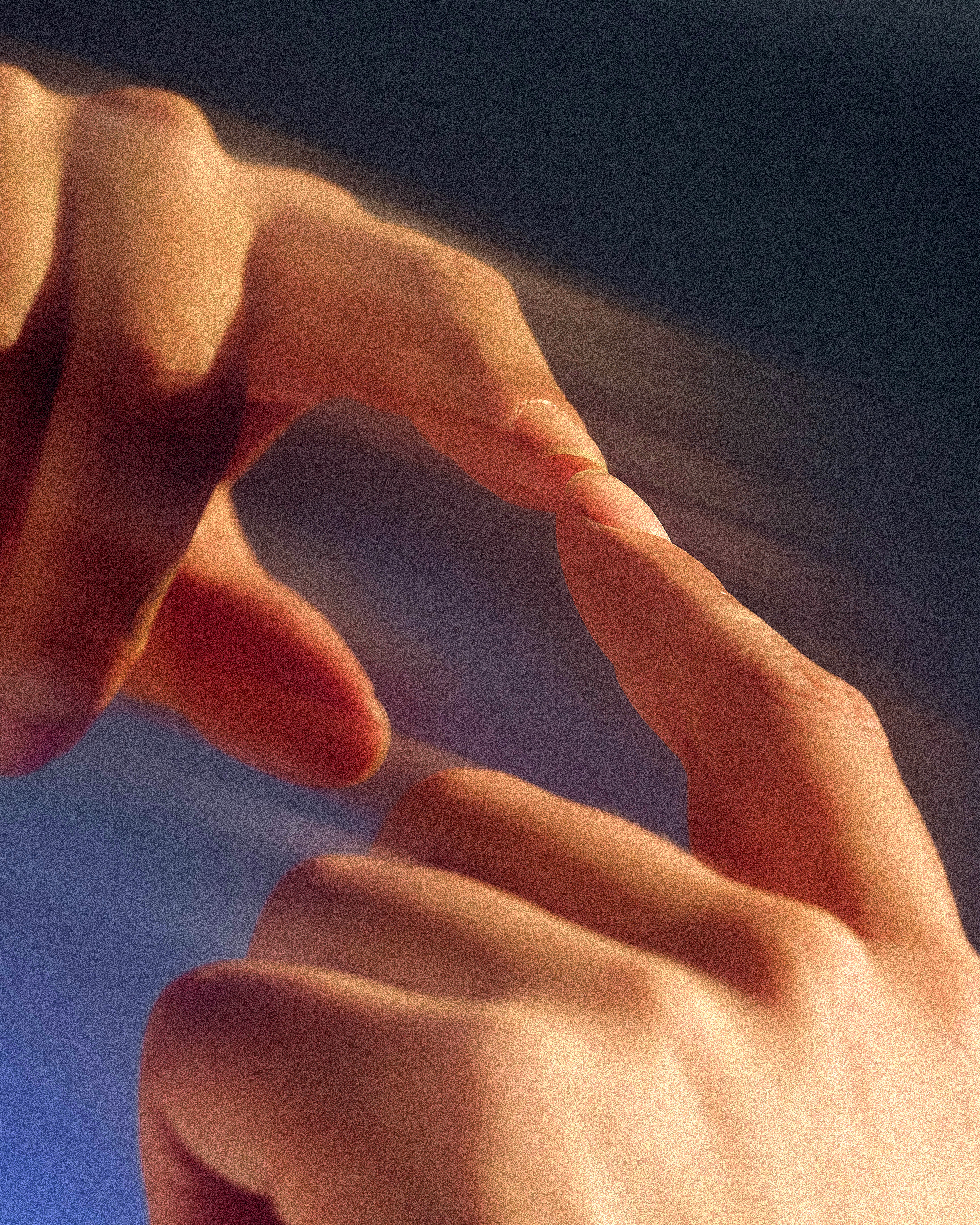 A grainy, close-up photograph of two index fingers reaching out to touch.