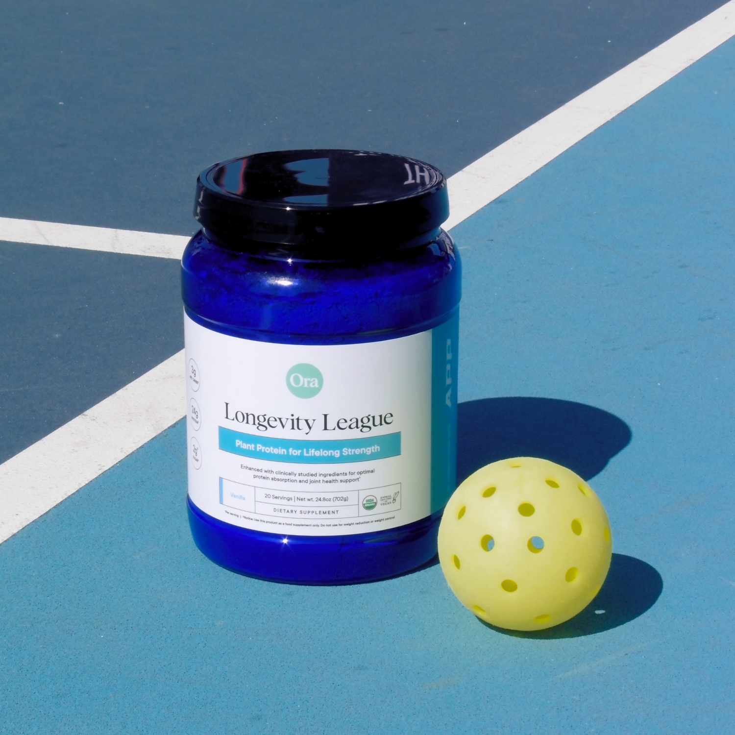 Blue protein powder container and yellow perforated ball on a blue sports court.