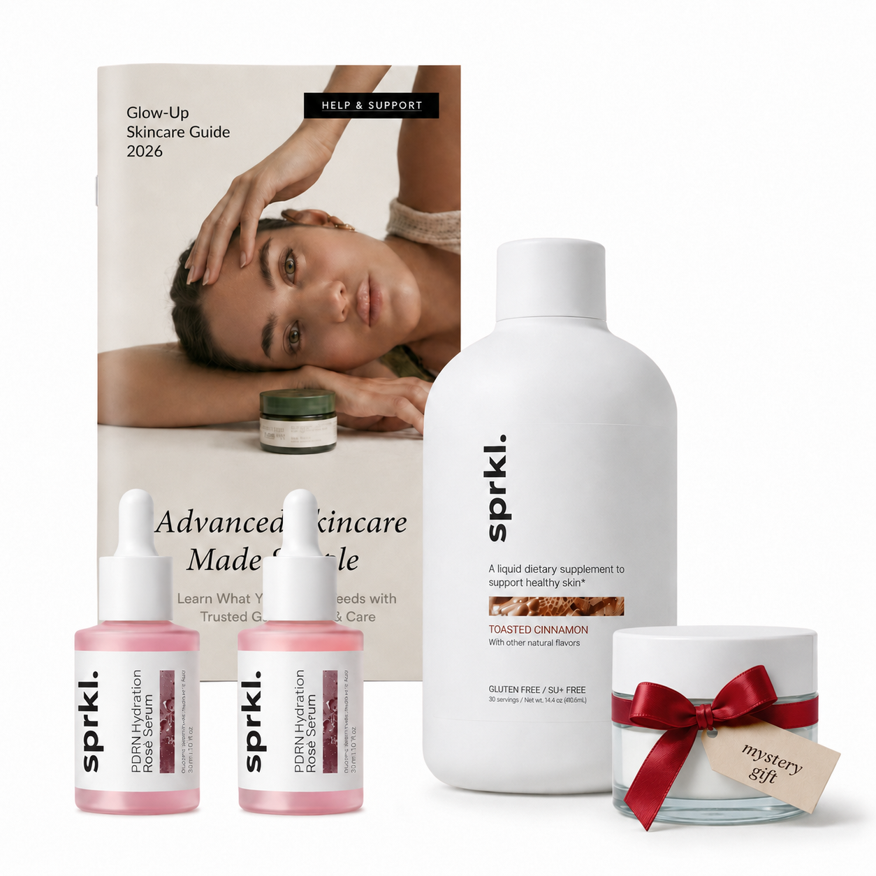 A collection of 'sprkl' skincare products, including serums, a supplement, a guide, and a mystery gift.