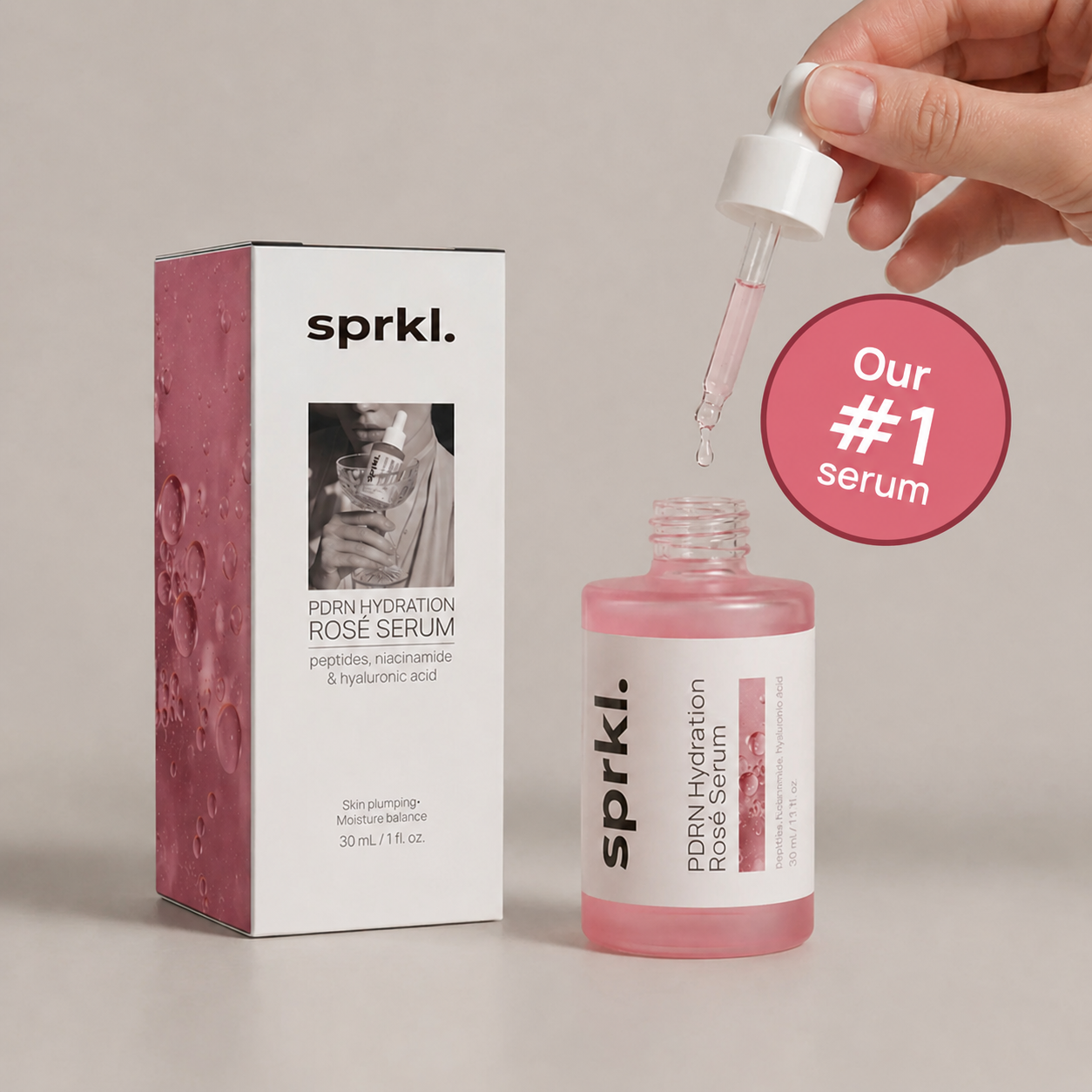 A bottle and box of sprkl. PDRN Hydration Rosé Serum with a hand holding a dropper.