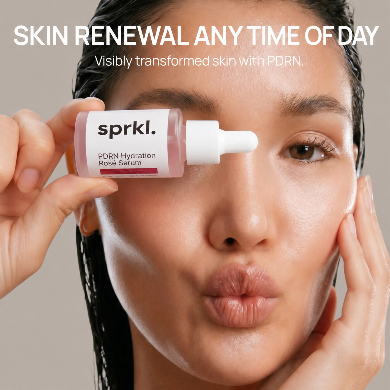 A woman with puckered lips holds a small bottle of sprkl. Hydration Rose Serum over one eye.