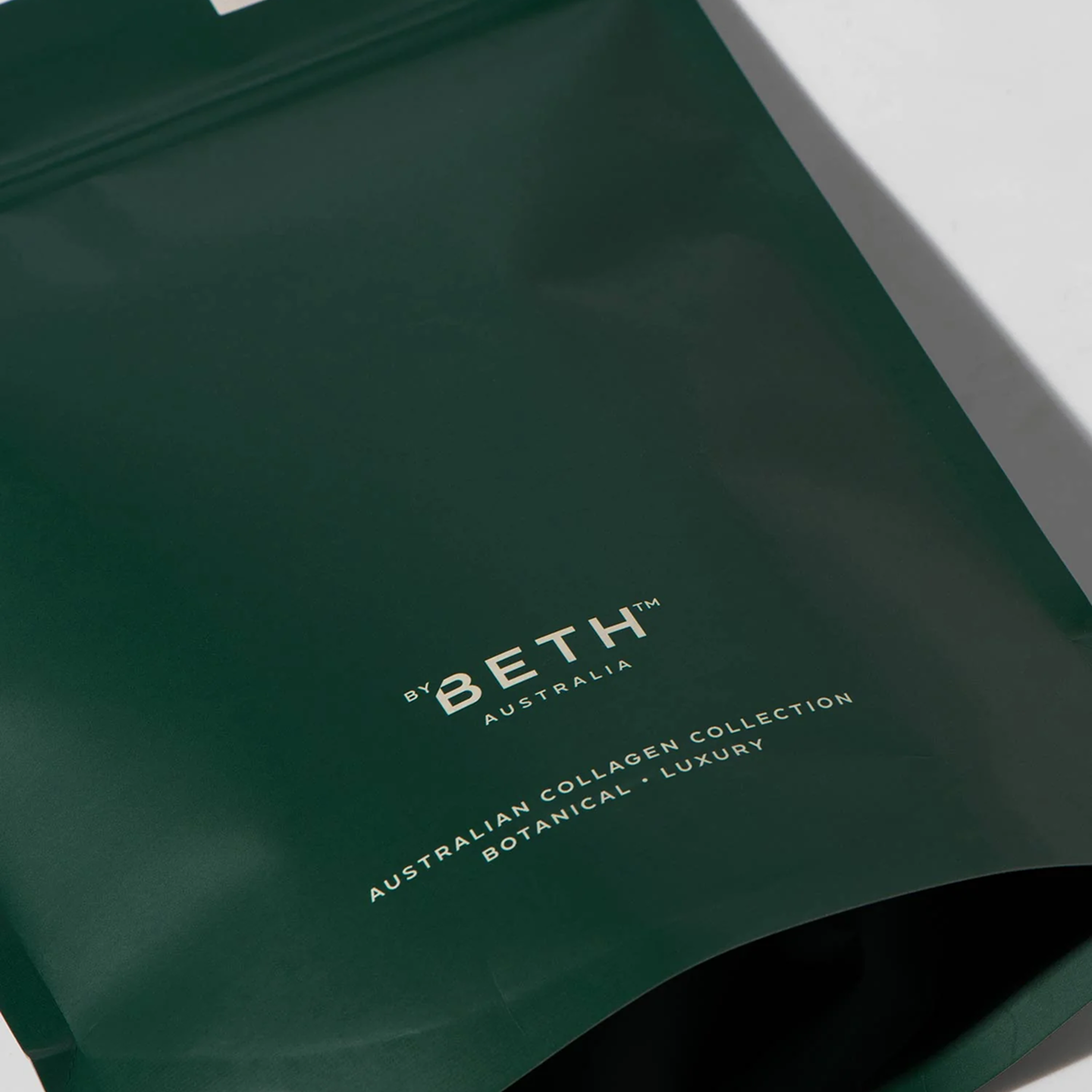 A close-up of a dark green pouch with the brand name 'By Beth Australia' printed on it.