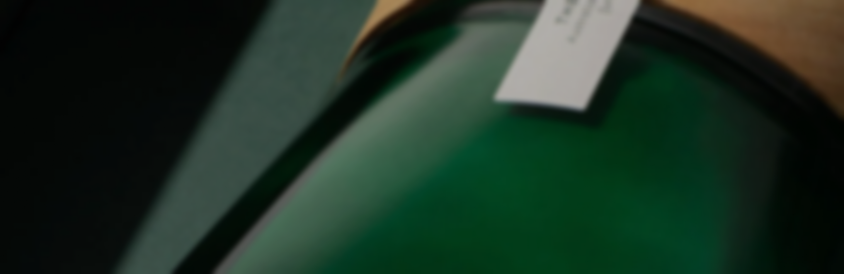 A blurry, close-up shot of a dark green object with a white tag on it.