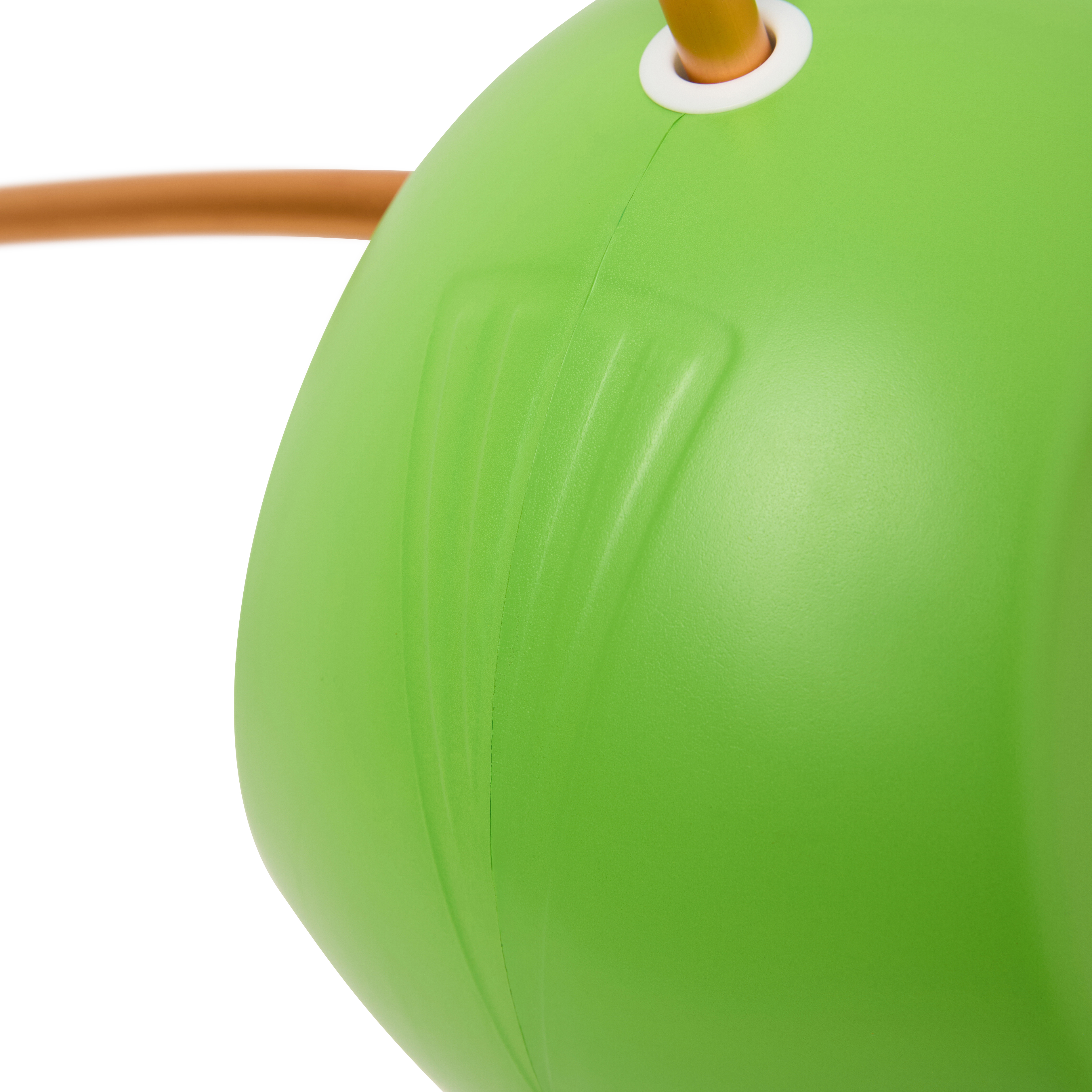 A close-up of a green plastic object with a textured surface and an orange handle.