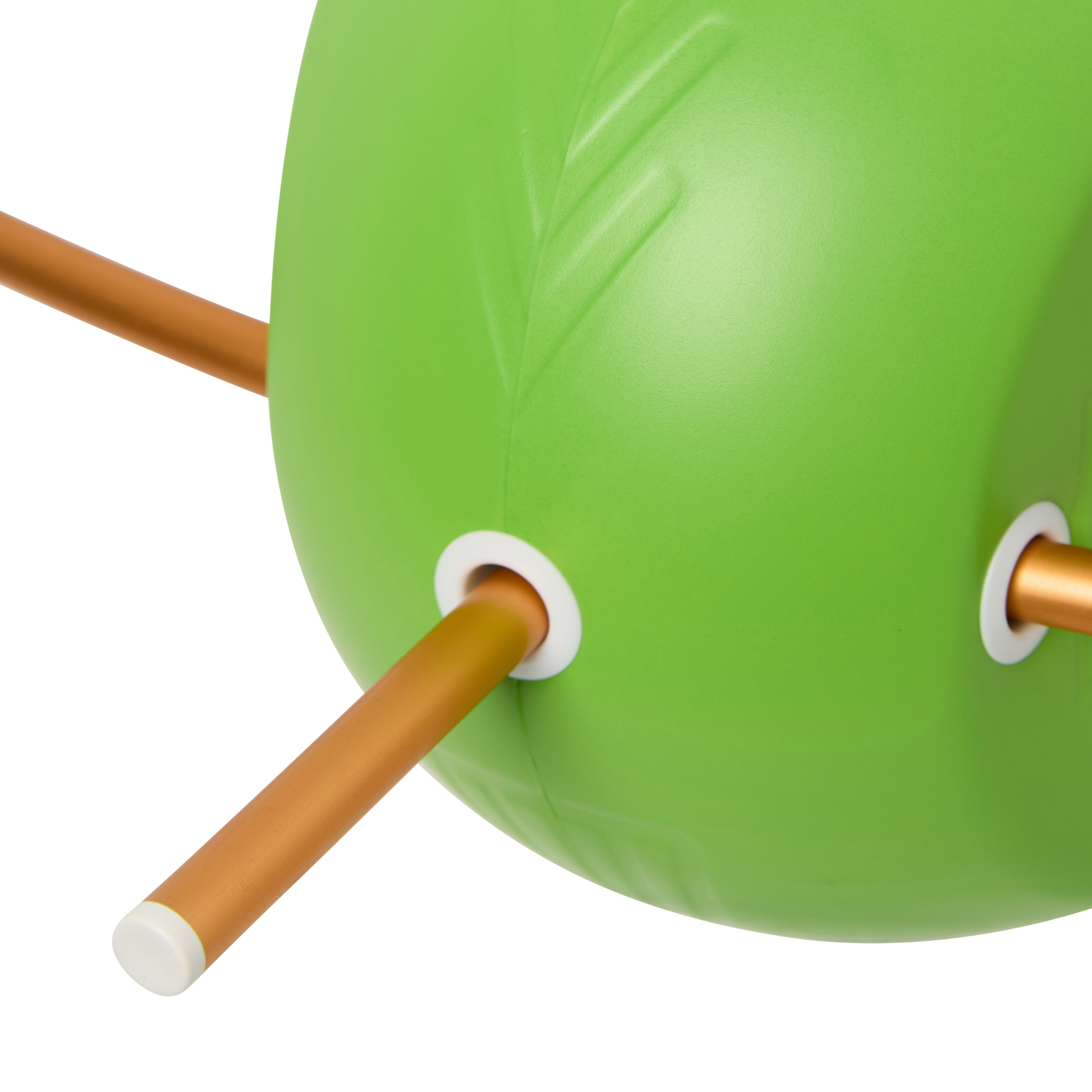 A close-up of a lime green plastic object with a leaf pattern and bronze-colored rods passing through it.