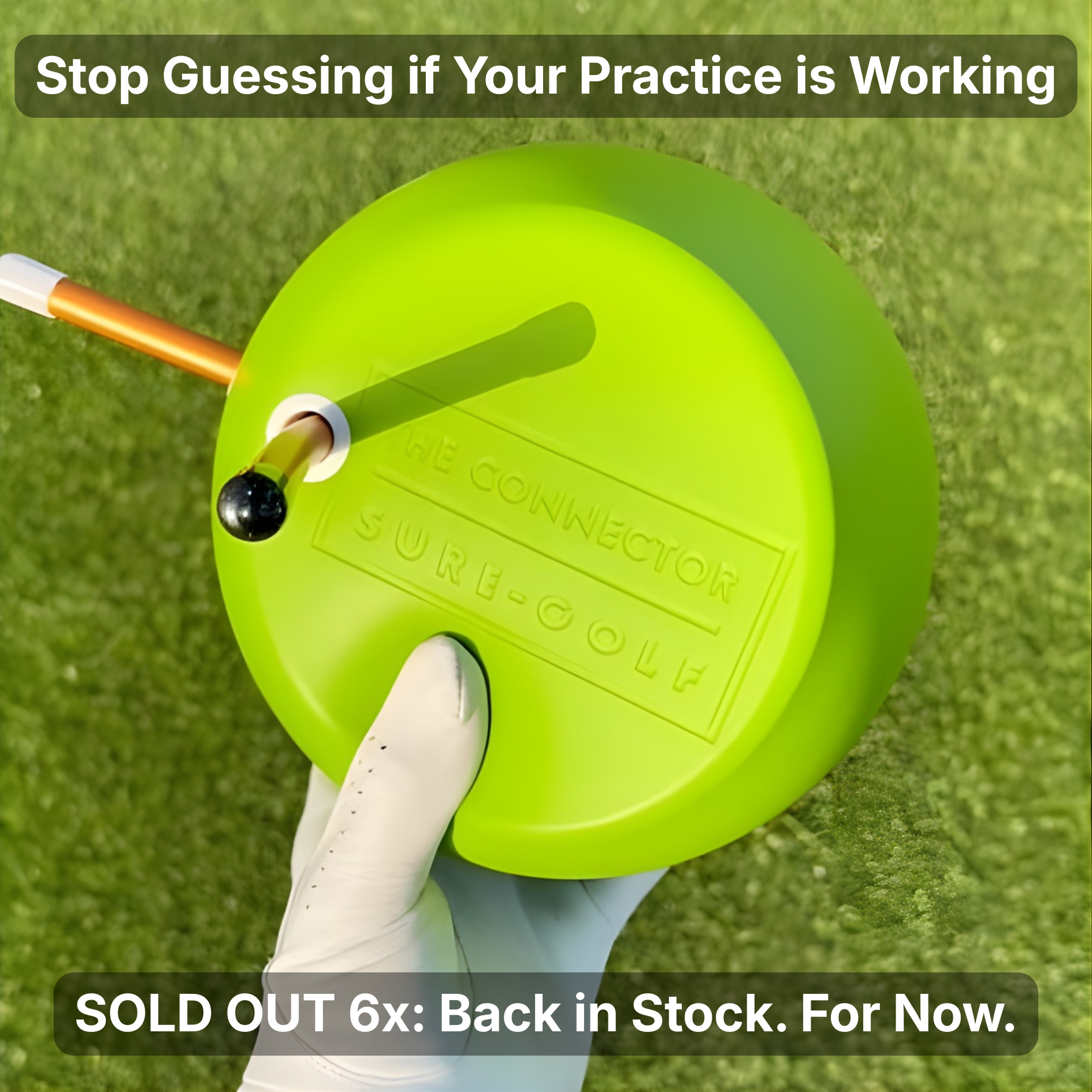 Green golf training aid held by a gloved hand on grass.