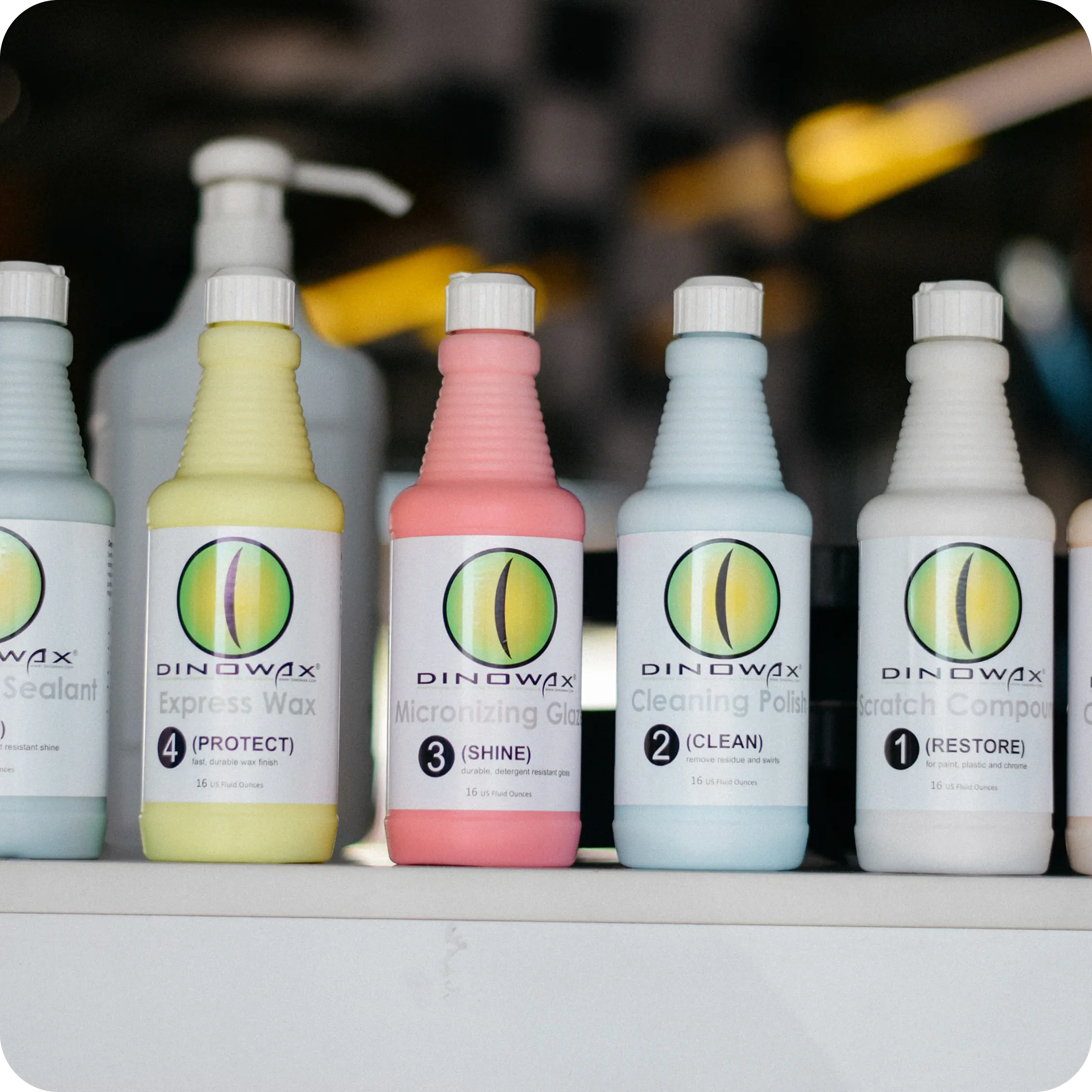 Bottles of Dinowax car care products in a row on a shelf.