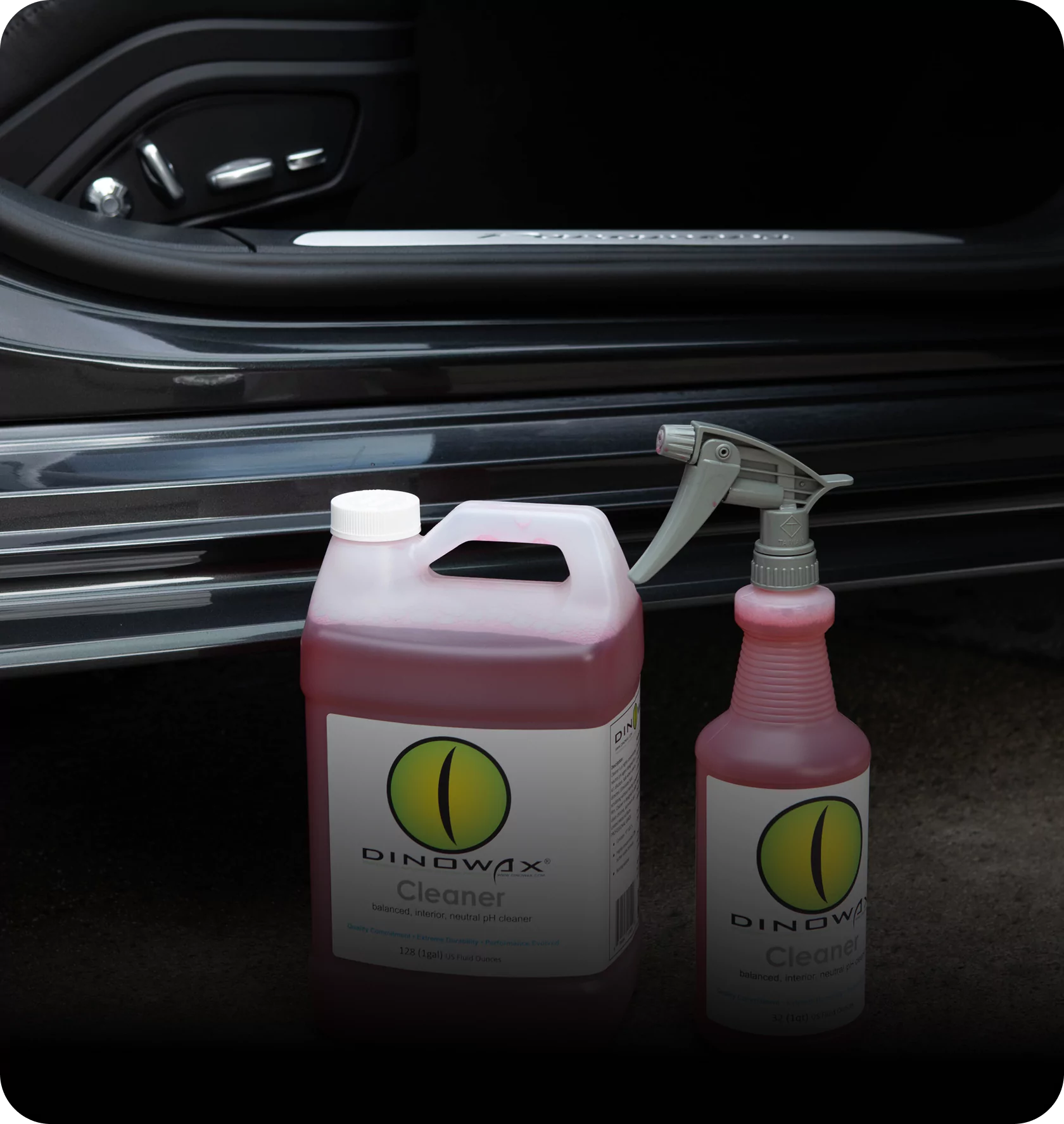 Dinowax cleaner bottles beside a car's open door.
