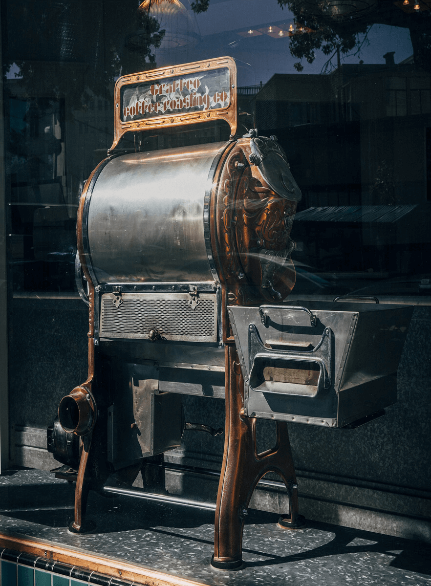 Vintage coffee roasting machine with a reflective surface.