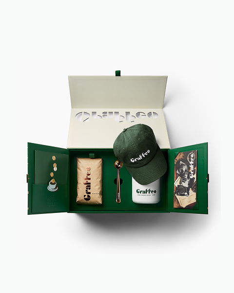 An open green gift box with 'Graffee' branded merchandise, including a hat, tumbler, and a bag of coffee.